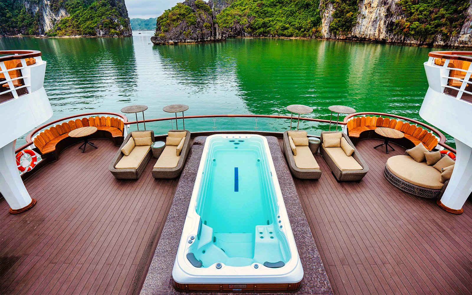 Jacuzzi on Ambassador cruise deck with scenic view of limestone cliffs in Halong Bay.