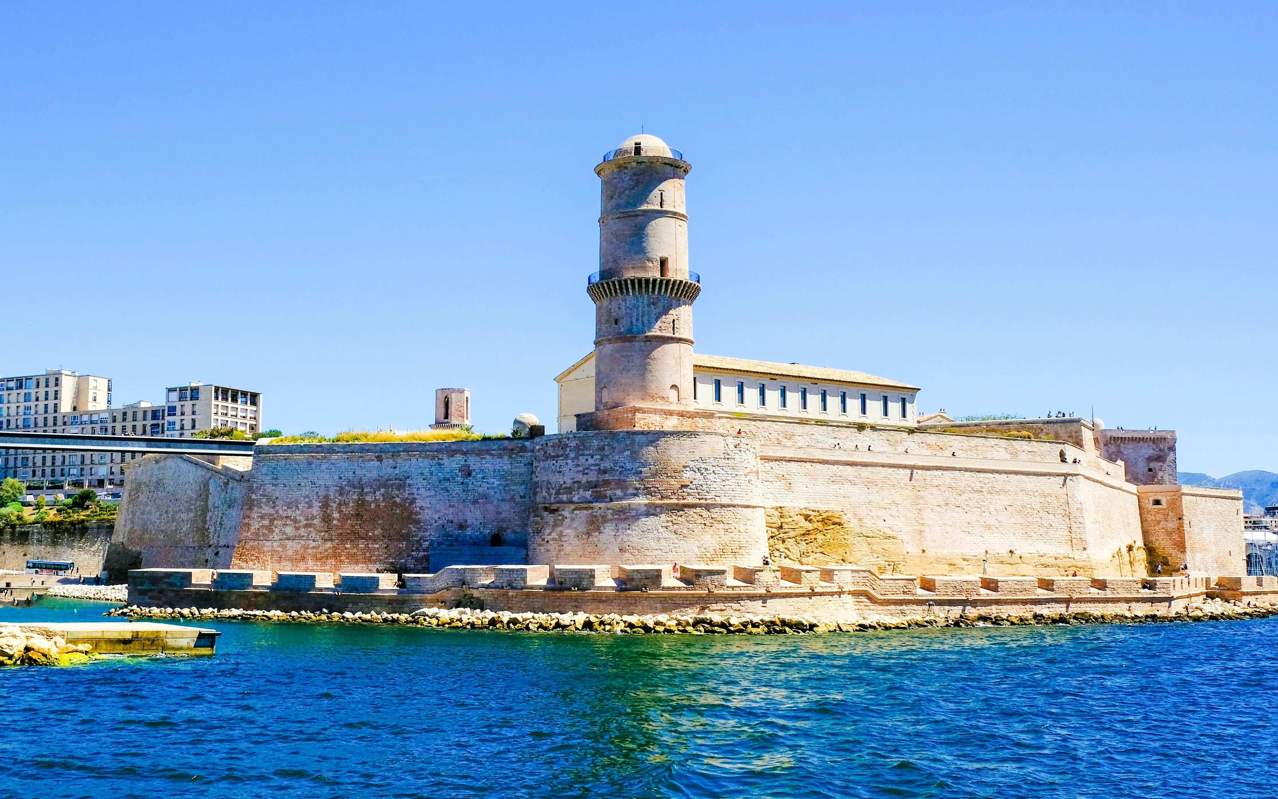 Fort Saint-Jean in Marseille, France, viewed from the water with clear blue sky.