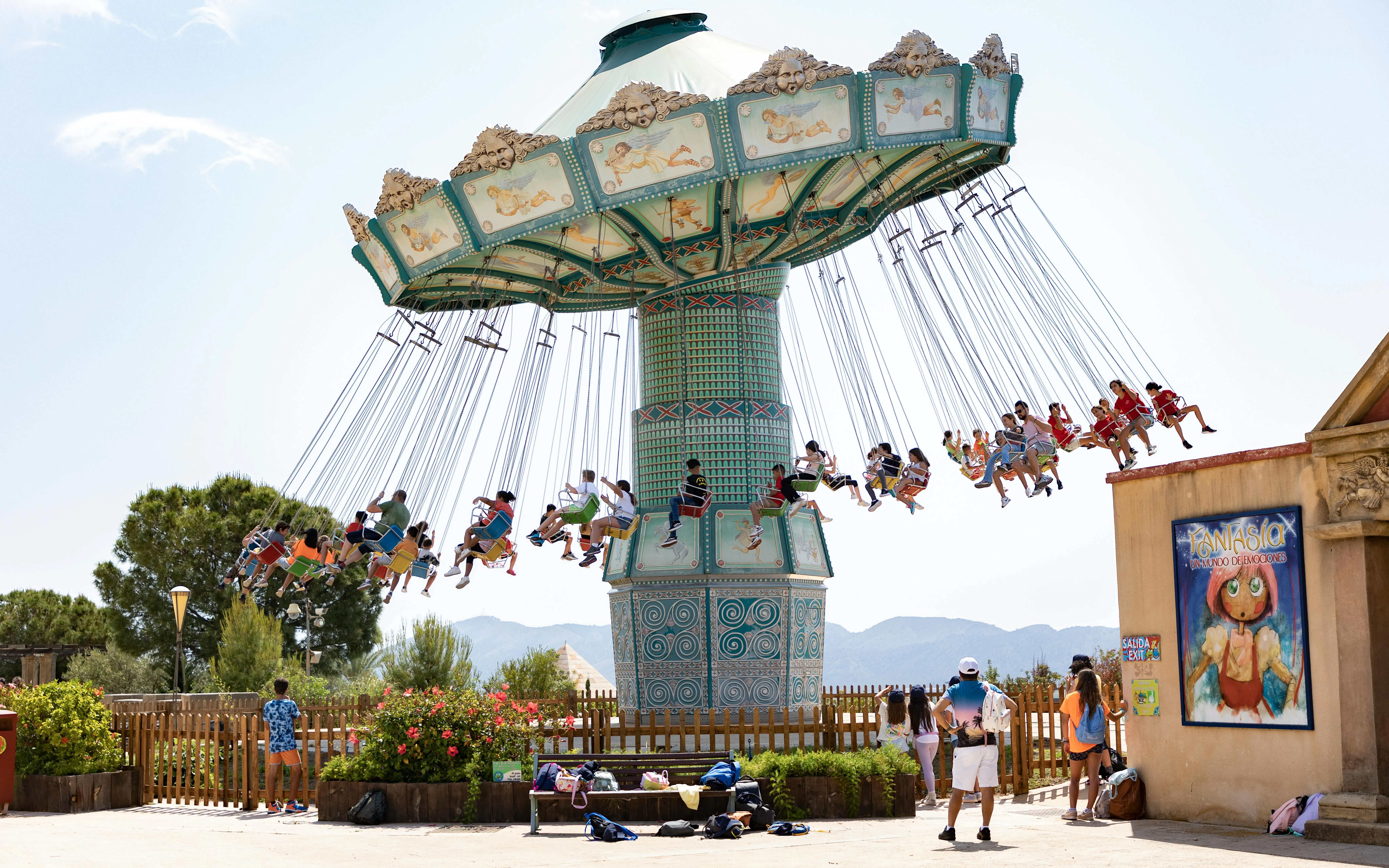 Visitors enjoying a swing ride at Terra Mitica theme park in Spain.