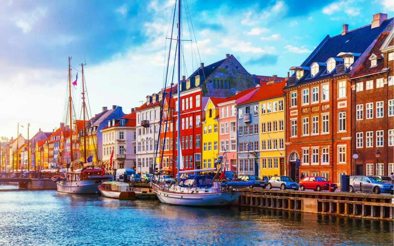 Colorful buildings and boats along Nyhavn canal, Copenhagen, part of the self-guided city exploration game.