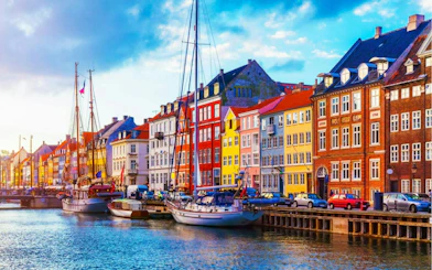 Colorful buildings and boats along Nyhavn canal, Copenhagen, part of the self-guided city exploration game.