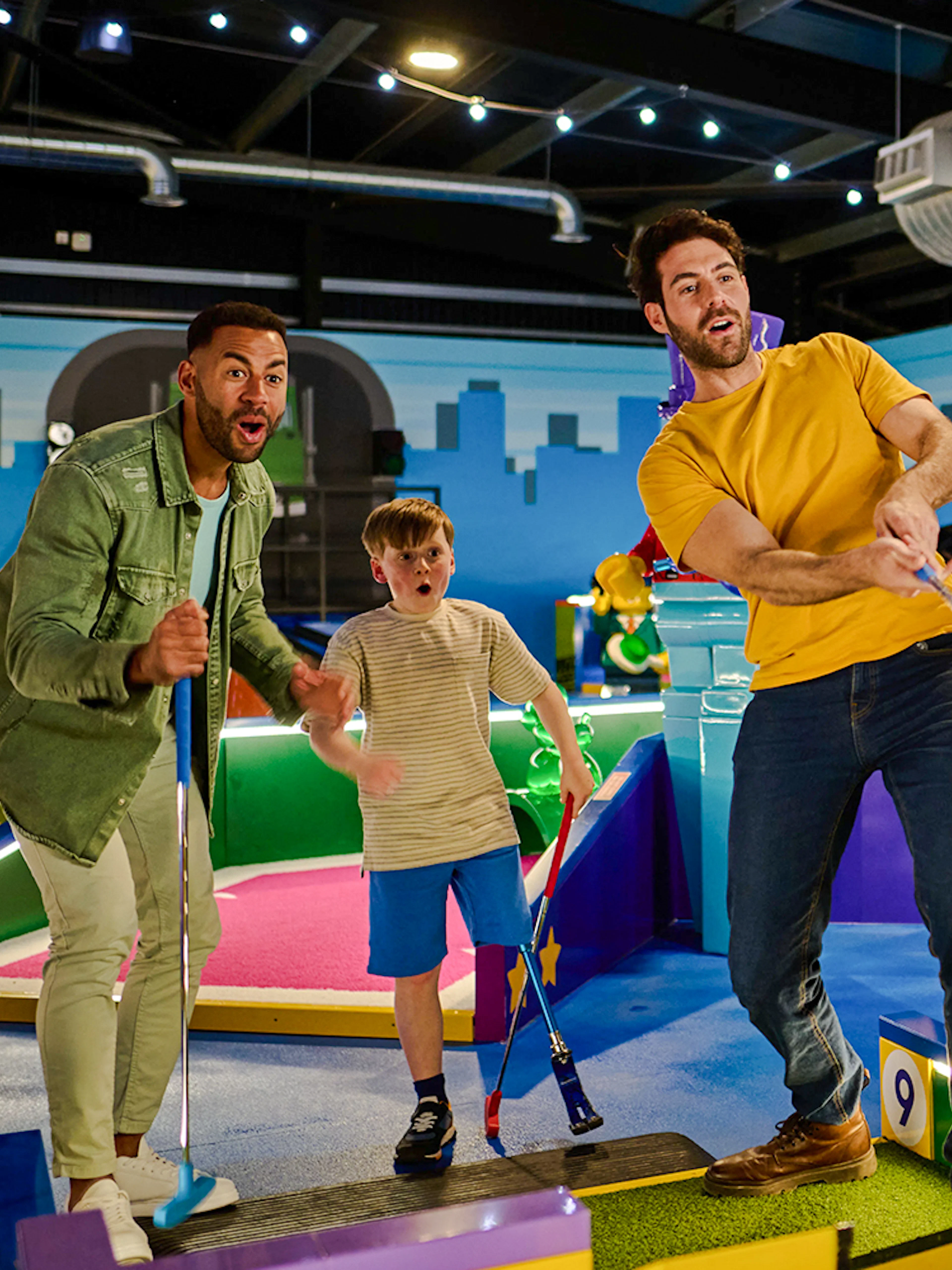 Group playing mini-golf at LEGOLAND® Adventure Golf with colorful LEGO obstacles.