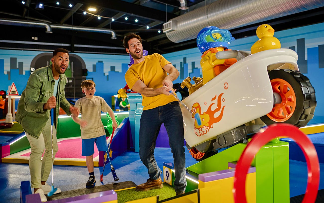 Miniature golf course with LEGO® structures at LEGOLAND® Adventure Golf, featuring colorful brick-built obstacles.