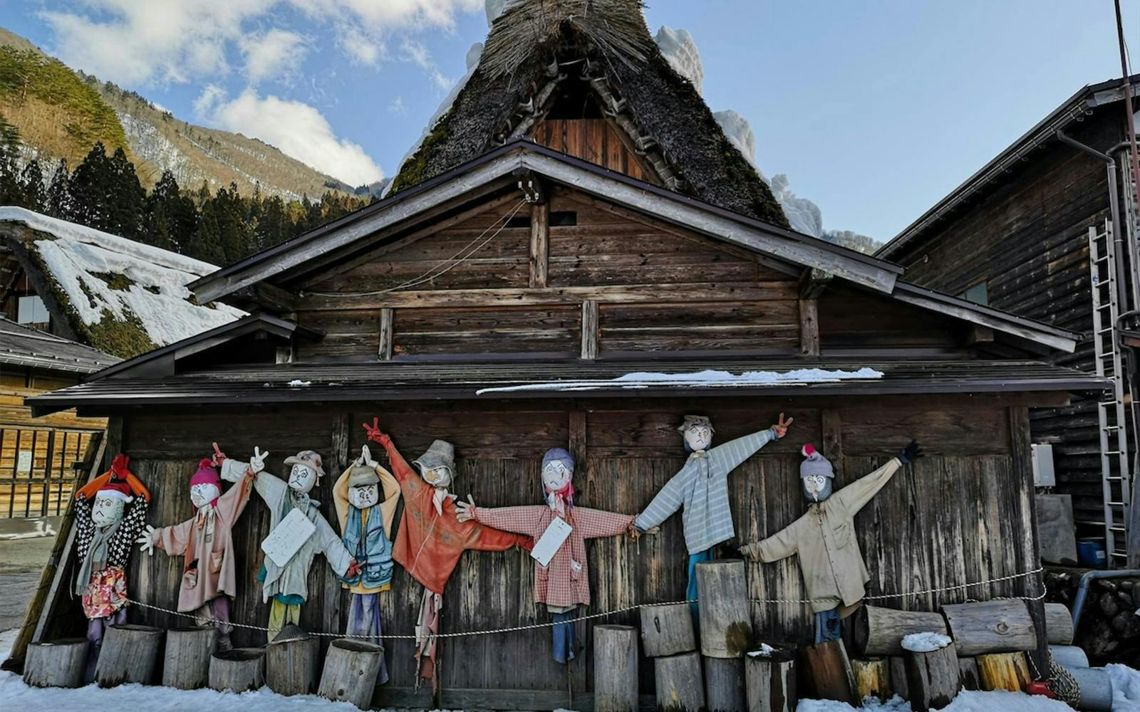Scarecrow display in front of a traditional gassho-zukuri house in Shirakawa-go village.