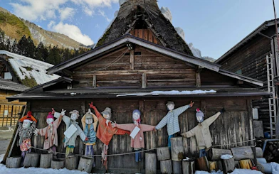 Scarecrow display in front of a traditional gassho-zukuri house in Shirakawa-go village.