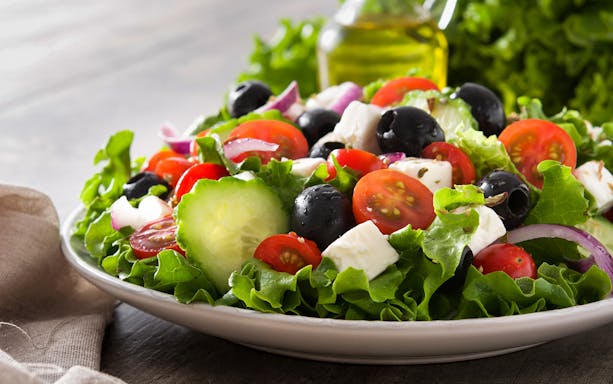 Greek salad with tomatoes, cucumbers, olives, and feta on Athens Original Vegan Tour.
