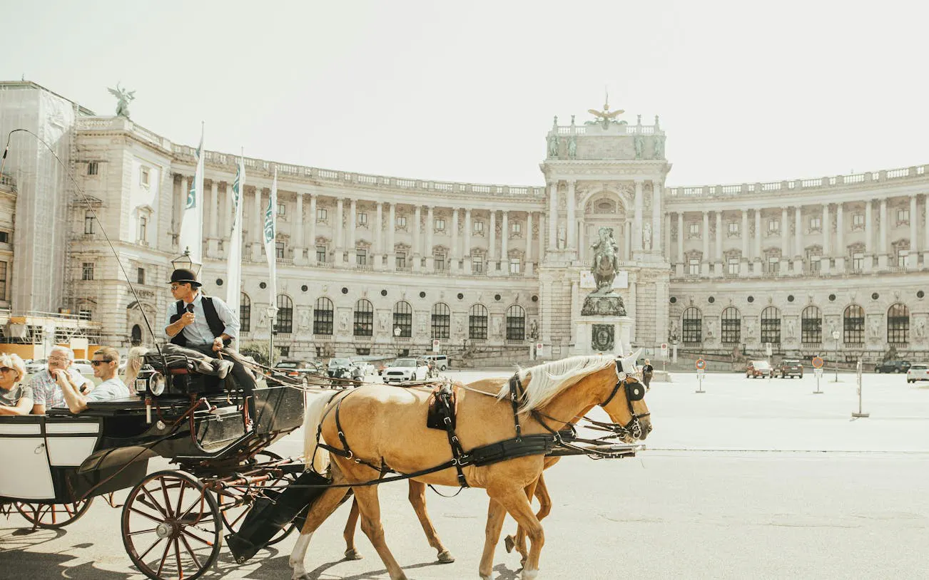 Horse-drawn carriage in front of Hofburg Palace, Vienna, part of self-guided city exploration game.