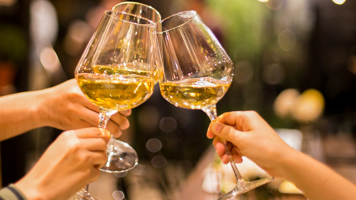 Hong Kong Wine & Dine Festival attendees enjoying wine tasting with city skyline backdrop.