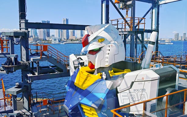 Gundam robot at Gundam Factory Yokohama with Yokohama skyline in the background.