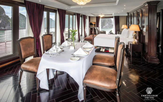 Luxury suite interior on Ha Long Bay 5-star Ambassador Cruise with dining table and bay view.