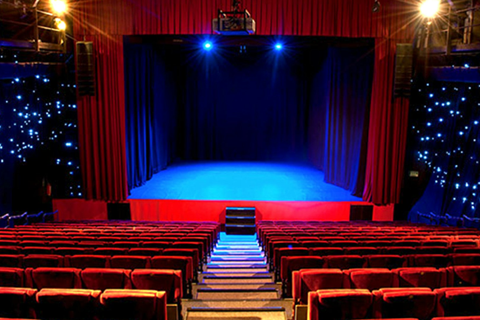 Seville Flamenco Theatre stage with red curtains and seating.