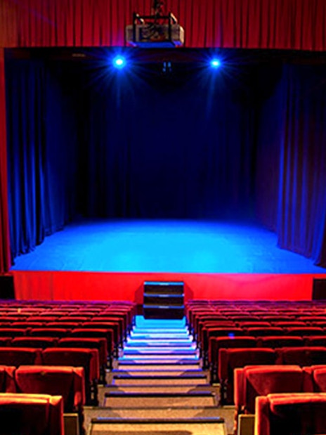 Seville Flamenco Theatre stage with red curtains and seating.