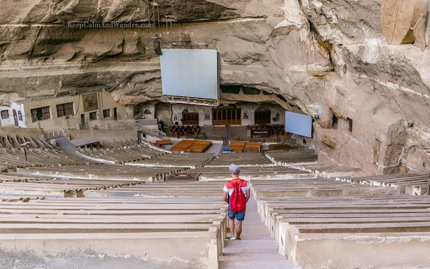 Man walking down steps in the rock-hewn St. Simon Monastery, Cairo tour.