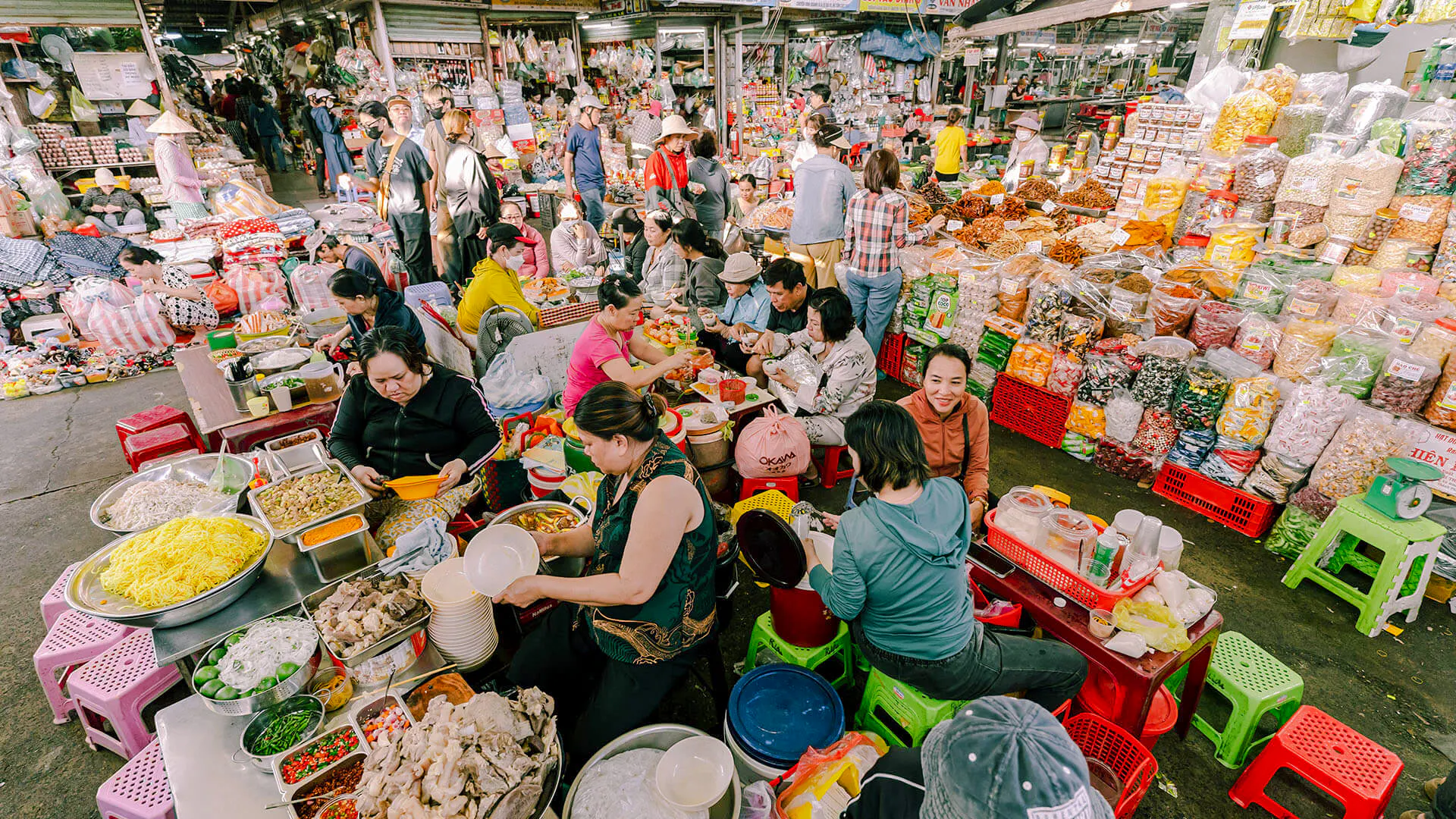 Bustling market scene with vendors and visitors enjoying local breakfast dishes in Da Nang.