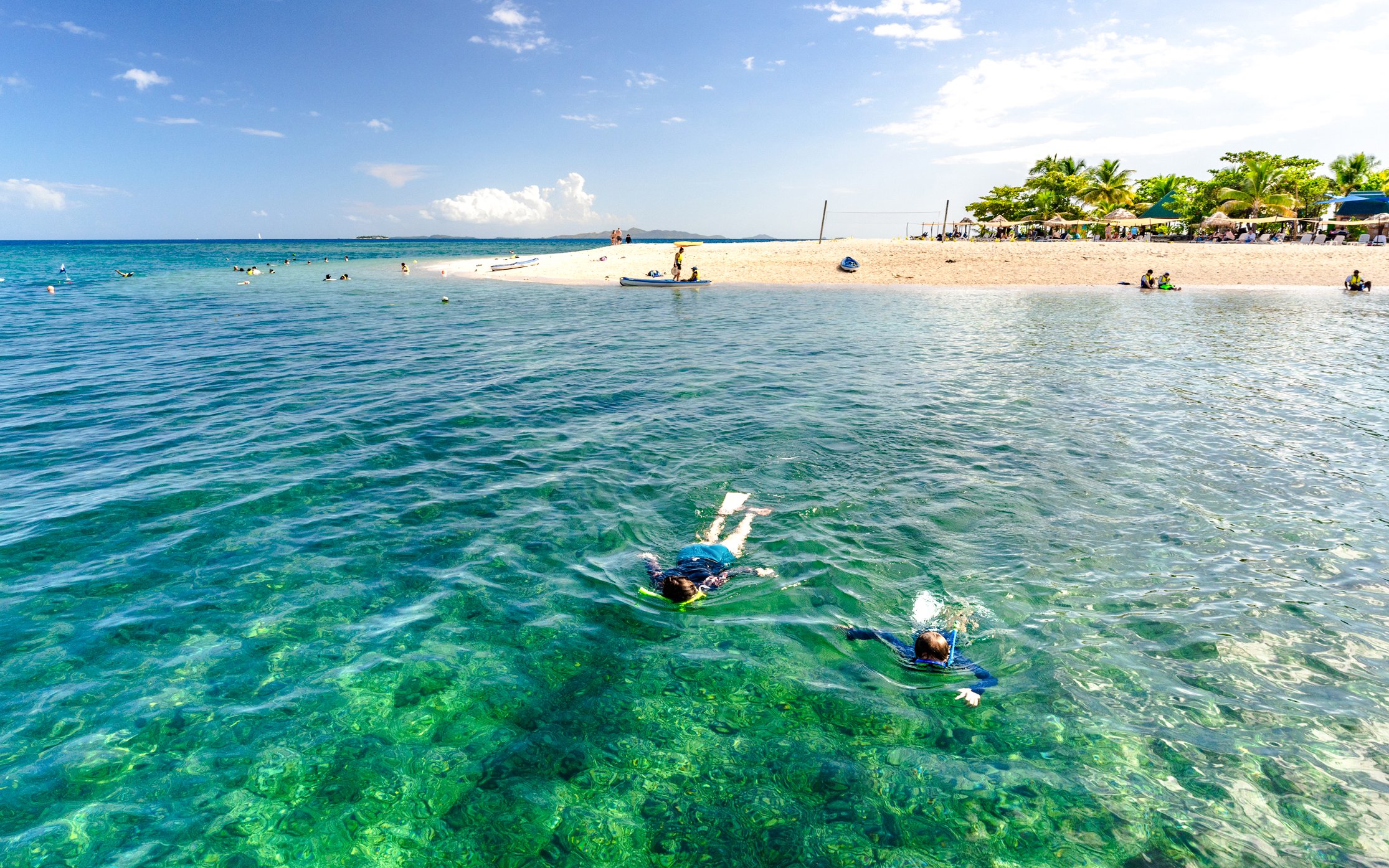 Snorkelers exploring clear waters near South Sea Island, Fiji.