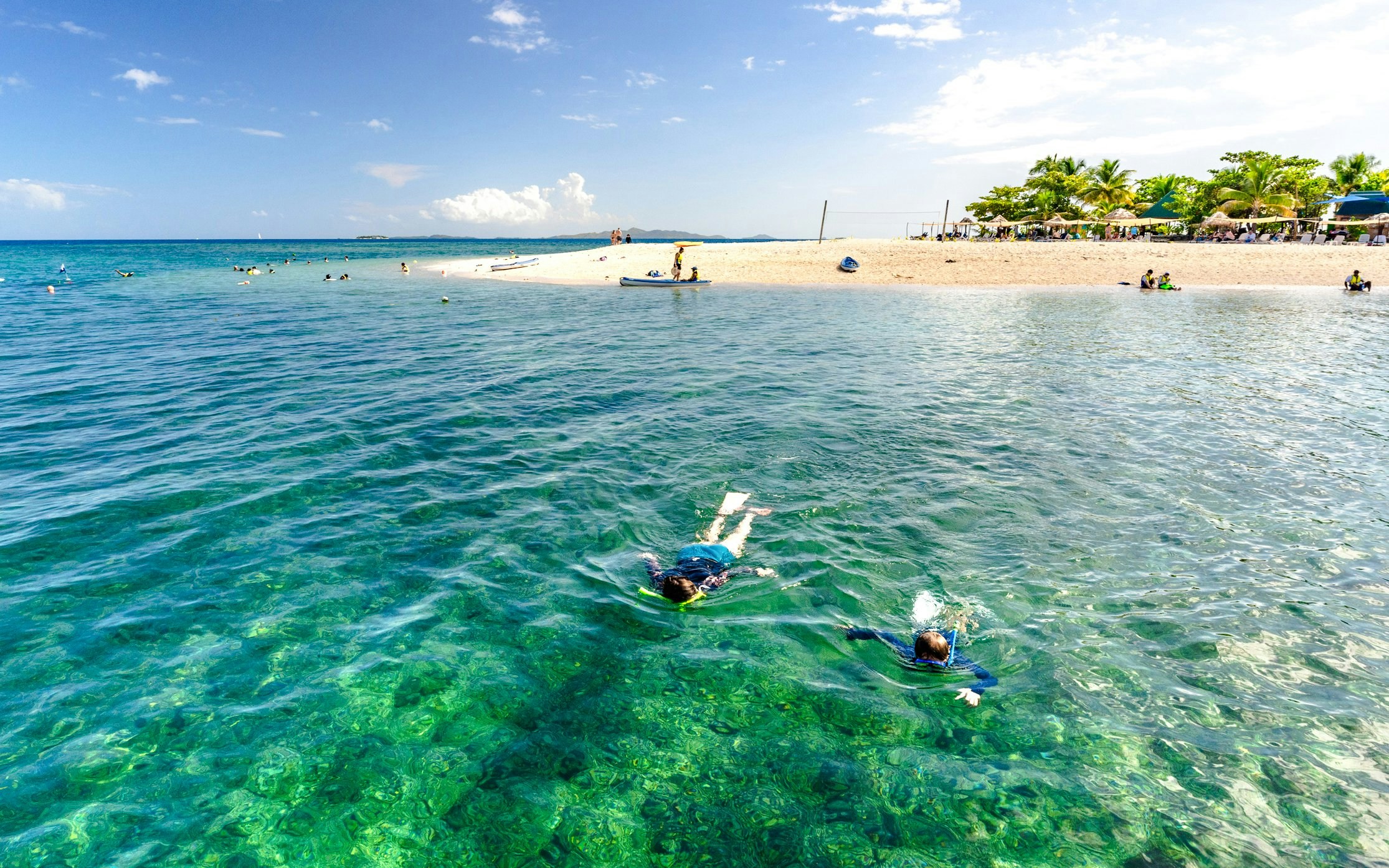 Snorkelers exploring clear waters near South Sea Island, Fiji.
