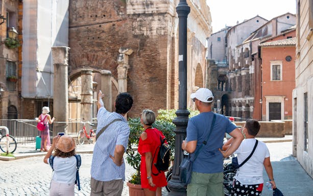 Tourists exploring ancient ruins on a walking tour of Rome's Jewish Ghetto.
