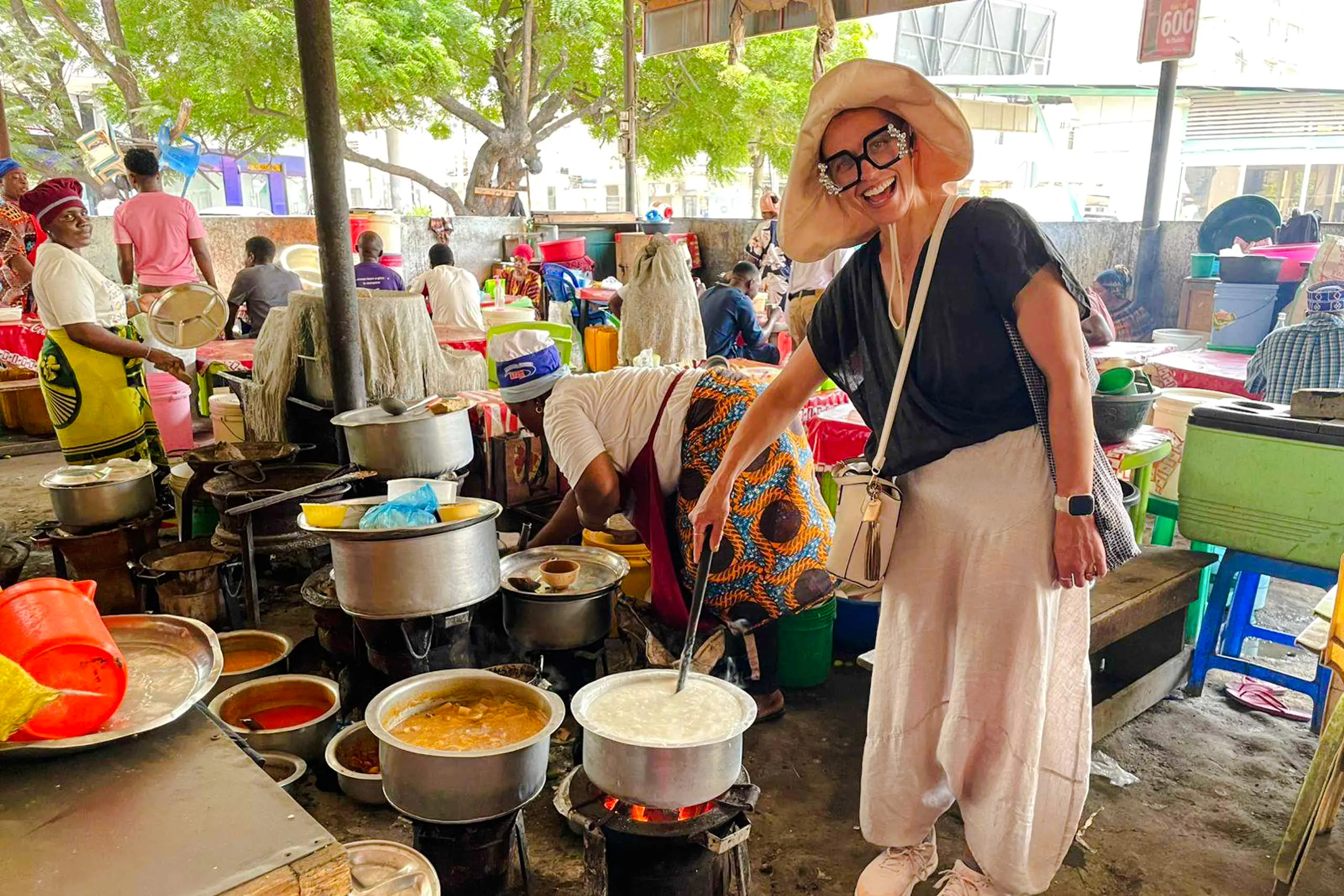 Tourist cooking local dishes at a vibrant market in Zanzibar.