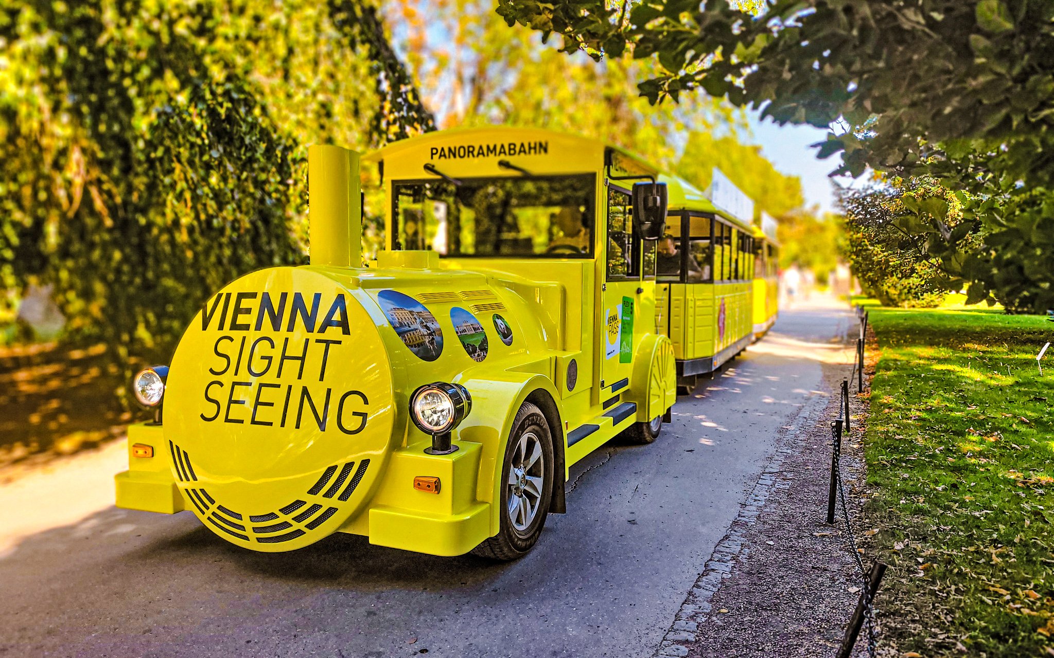 Yellow panoramic sightseeing train at Schonbrunn Palace, Vienna.