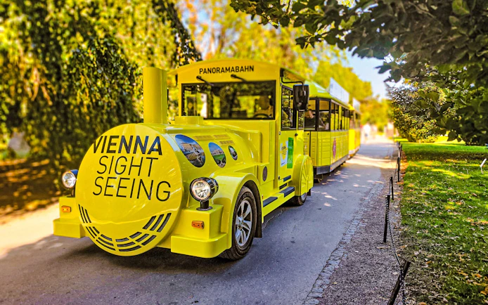 Yellow panoramic sightseeing train at Schonbrunn Palace, Vienna.