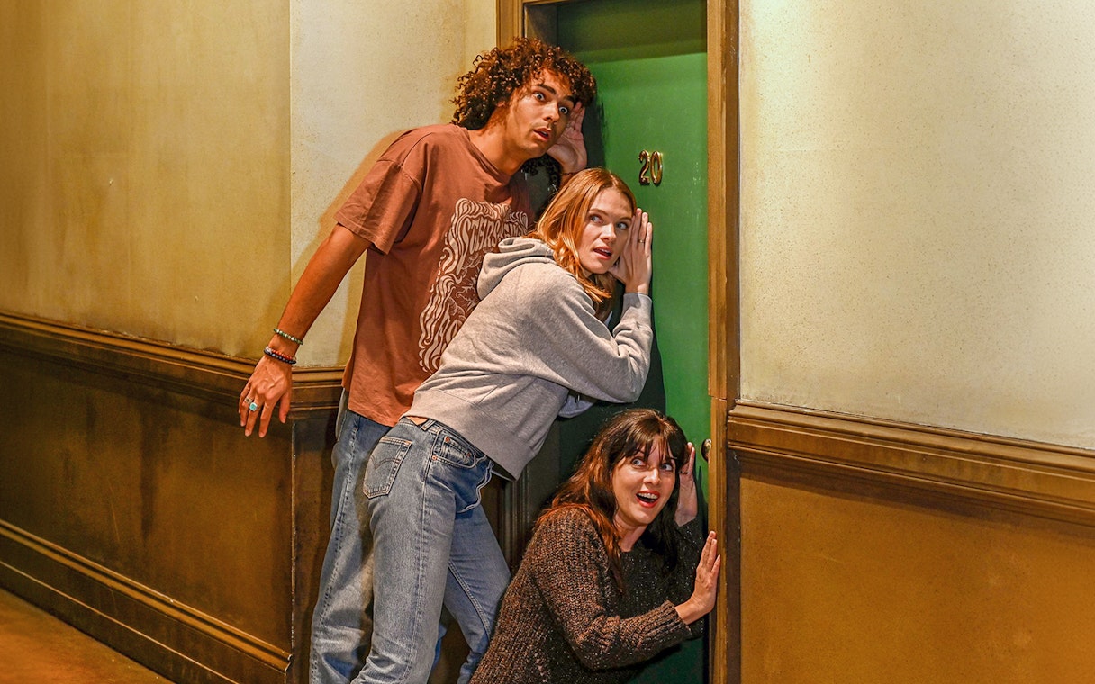 Visitors at The FRIENDS™ Experience in London listening at a green door marked 20.