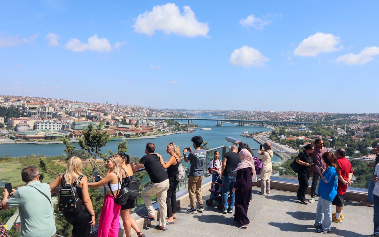 Tourists enjoying the view of Istanbul from Pierre Loti Hill, overlooking the Golden Horn.
