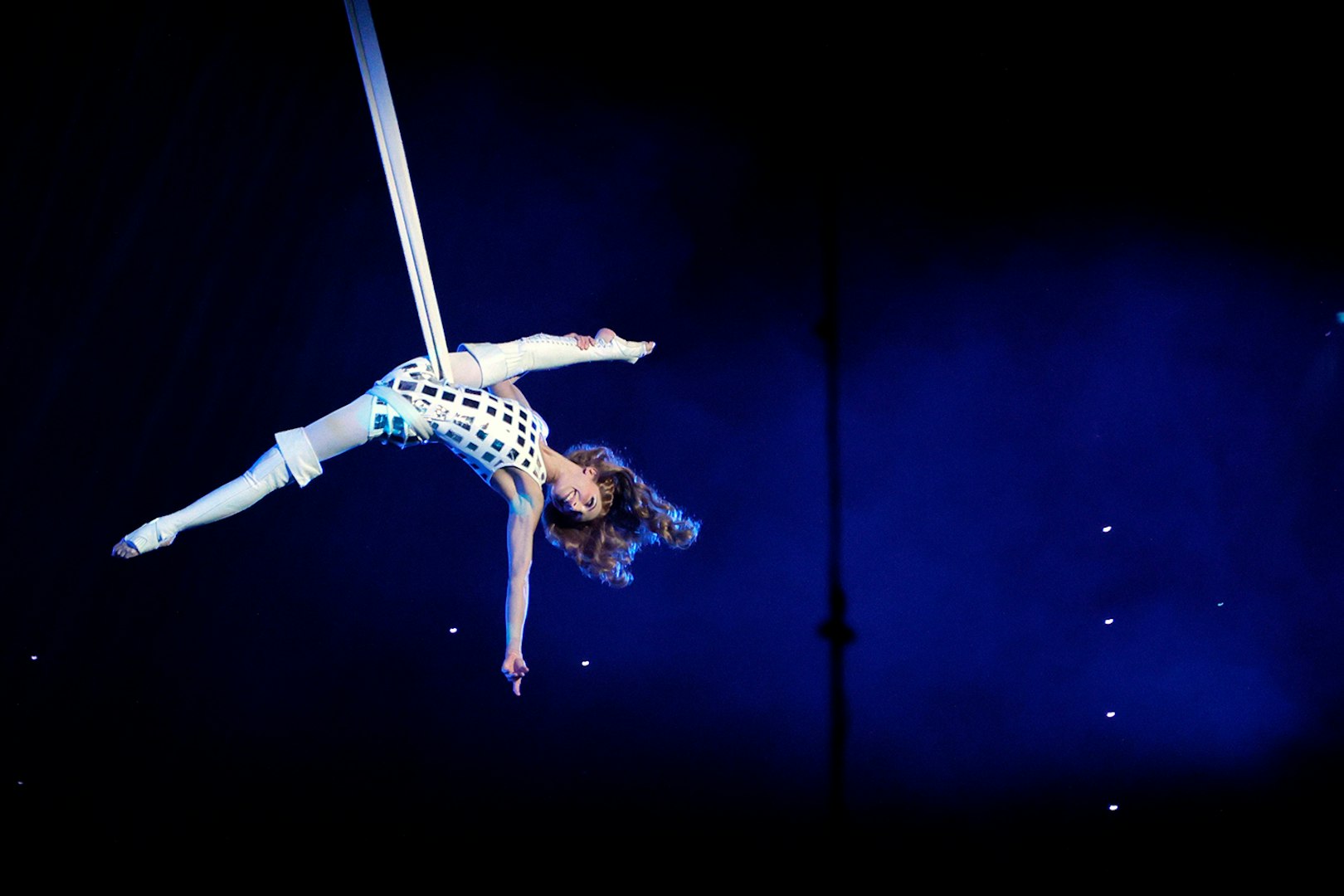 Aerial performer in The Beatles LOVE show, suspended mid-air on silk ropes.