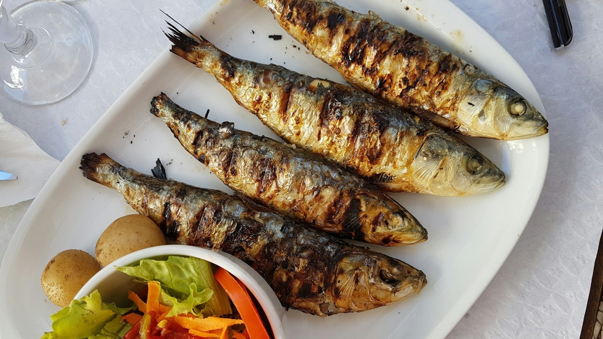grilled fish with vegetable salad on white ceramic plate