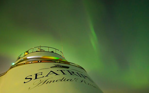 Northern lights over yacht deck on Northern Lights Yacht Cruise.