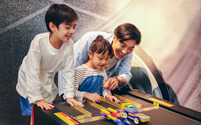 Children and adult playing with LEGO cars at LEGOLAND Discovery Center Tokyo.