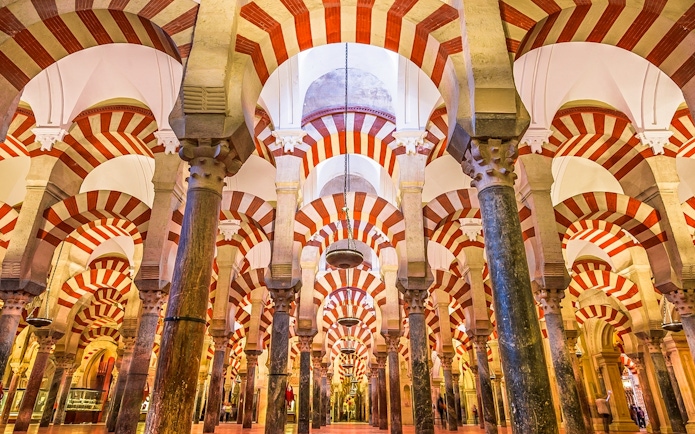 Interior of the Mosque-Cathedral of Córdoba with red and white arches.