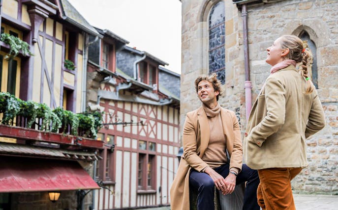 Tourists exploring historic architecture in Honfleur during a private tour from Paris.
