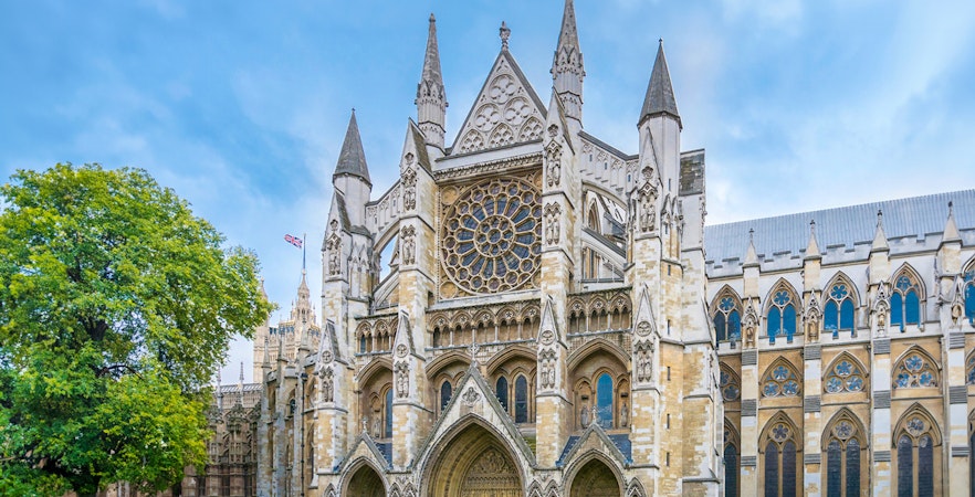 Westminster Abbey facade with visitors, London.