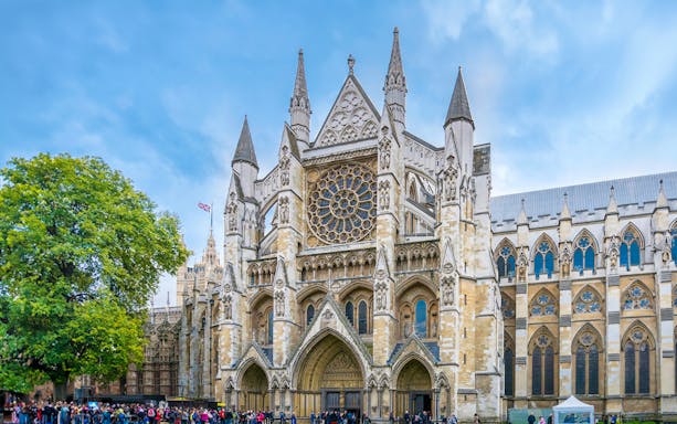 Westminster Abbey facade with visitors, London.