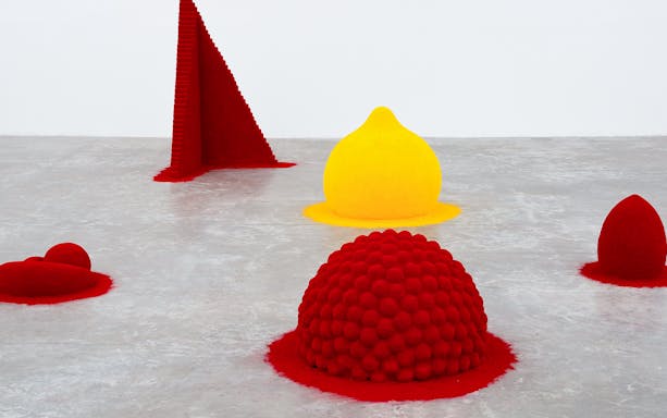 Colorful geometric sculptures by Anish Kapoor in a gallery setting.