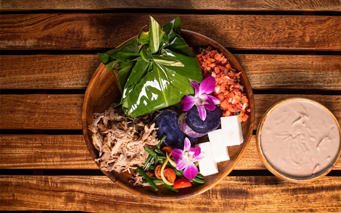 Traditional Hawaiian feast with taro, pork, and tropical flowers at Old Lahaina Luau.