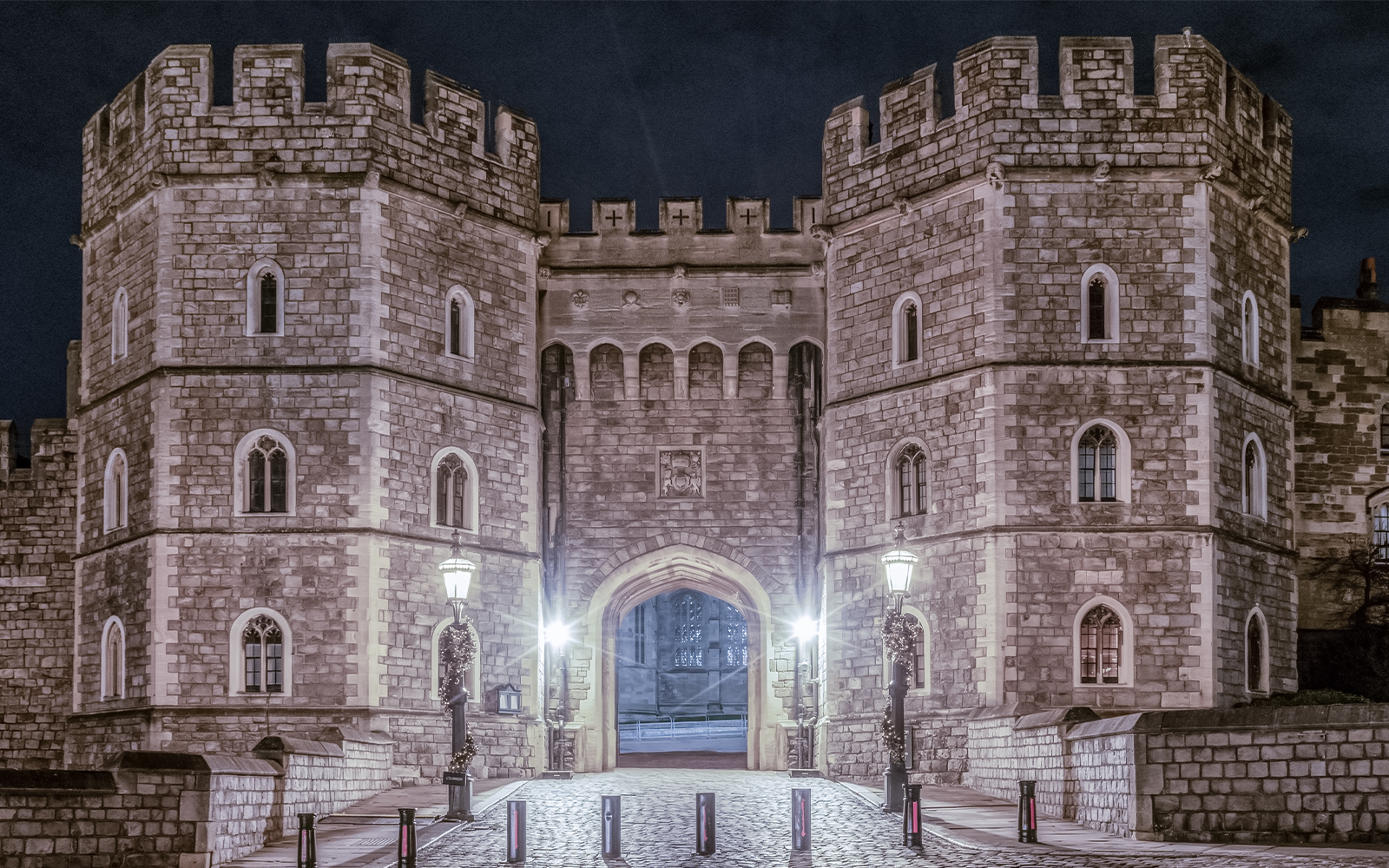 King Henry VIII Gate at Windsor Castle illuminated at night.