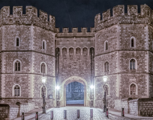 King Henry VIII Gate at Windsor Castle illuminated at night.