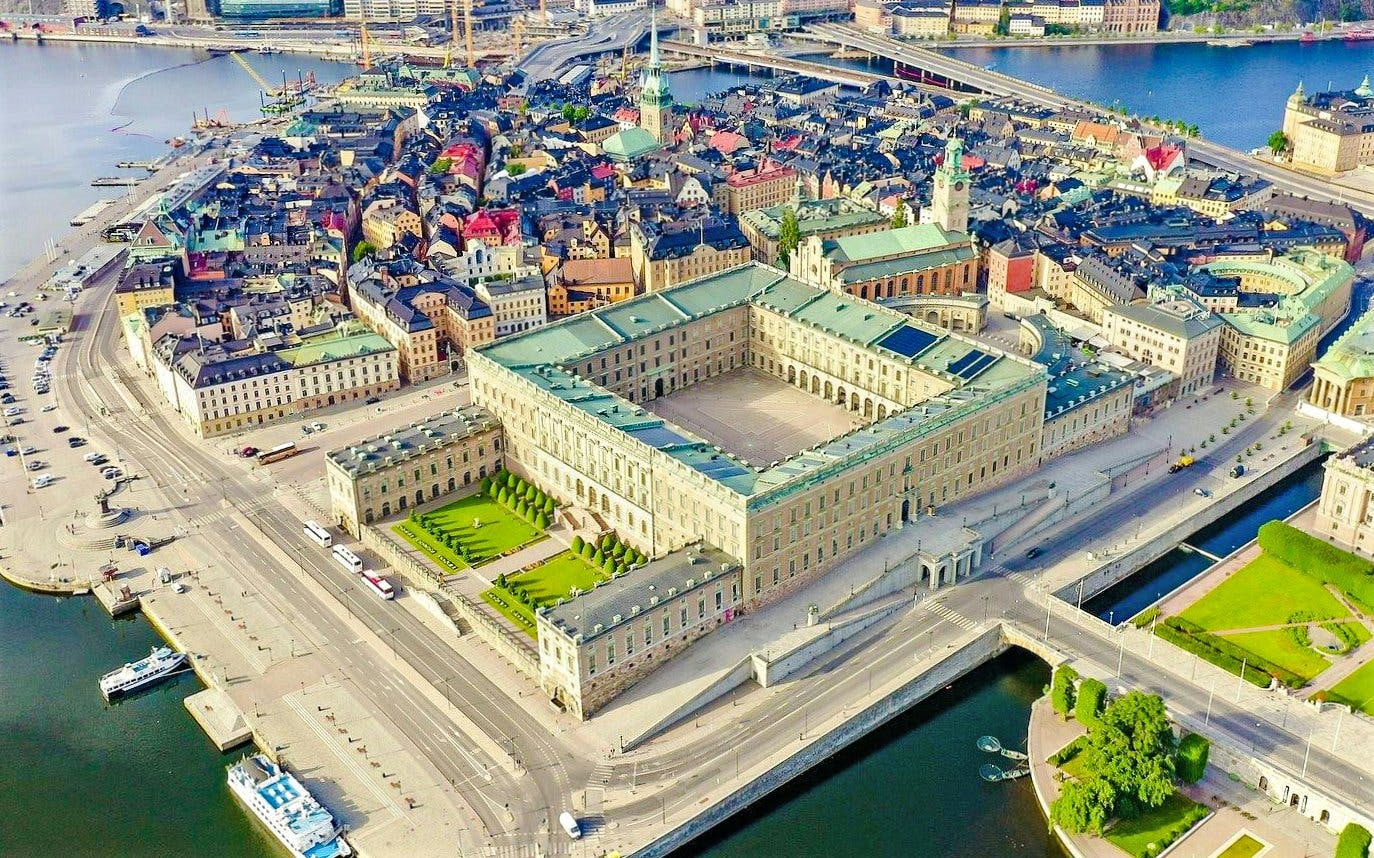 Aerial view of the Royal Palace in Stockholm surrounded by cityscape and waterways.
