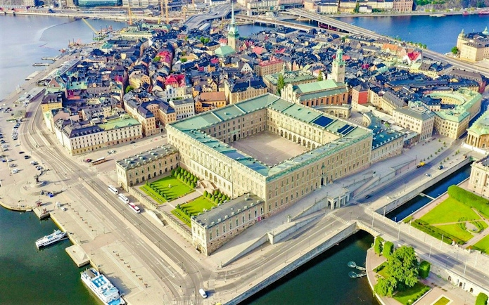 Aerial view of the Royal Palace in Stockholm surrounded by cityscape and waterways.