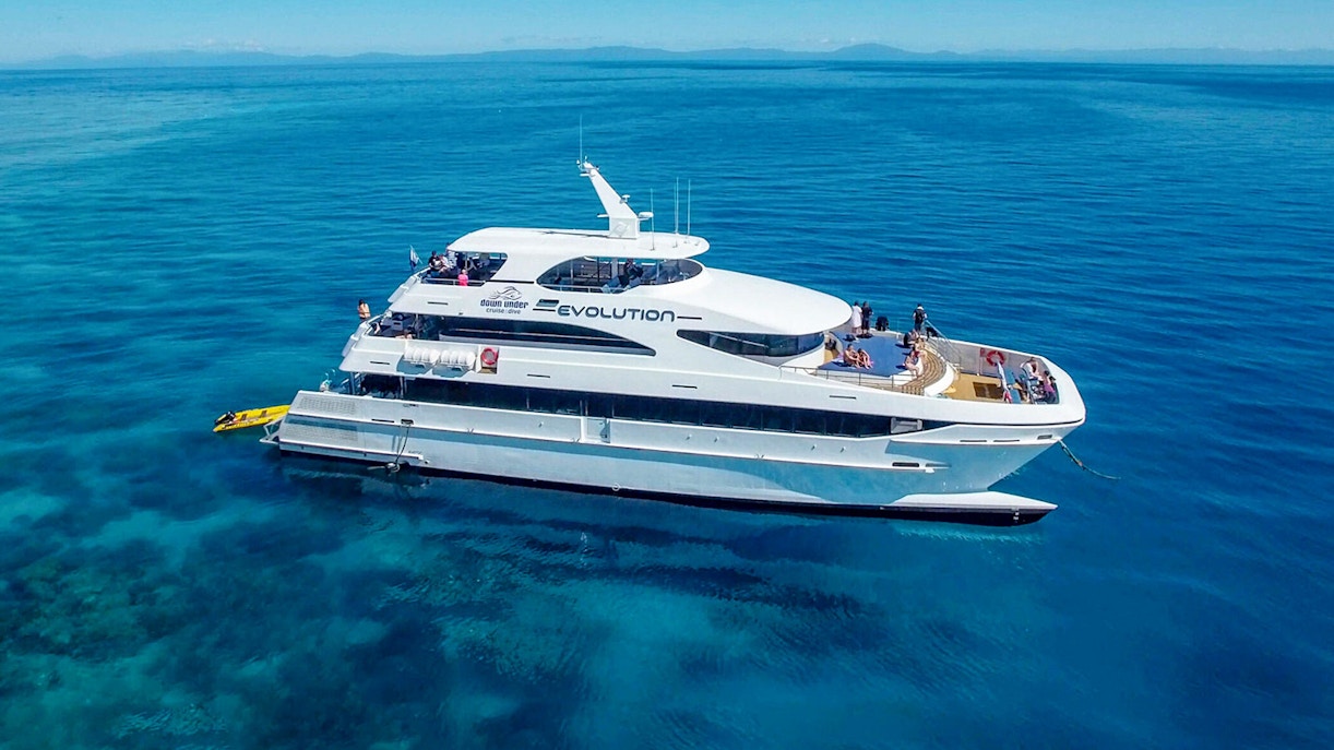 Cruise ship on the Great Barrier Reef with passengers enjoying the view.