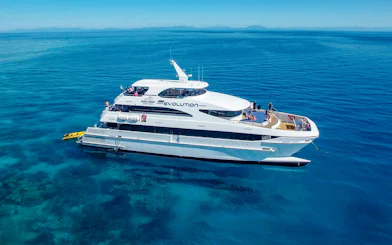 Cruise ship on the Great Barrier Reef with passengers enjoying the view.