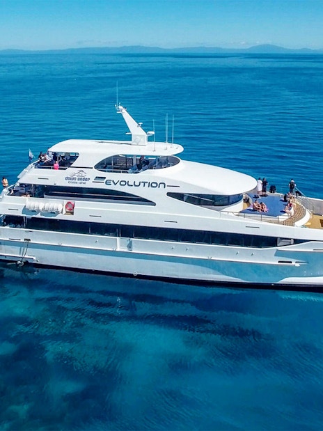 Cruise ship on the Great Barrier Reef with passengers enjoying the view.