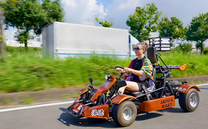 Woman driving a gokart on Osaka street during 90-minute tour.