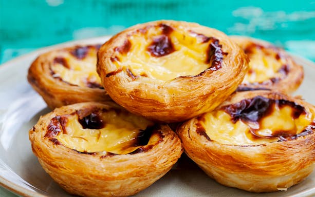 Egg tarts on a plate, featured in Singapore's Chinatown Hawker Food Tasting Tour.