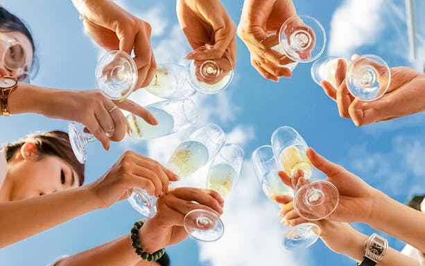 Tourists raising glasses for welcome drinks during Nusa Penida Manta Point Snorkelling Day Tour.