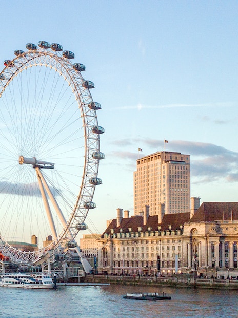 Tootbus passing the London Eye on a sunny day during the London Hop-On-Hop-Off Bus Tour.