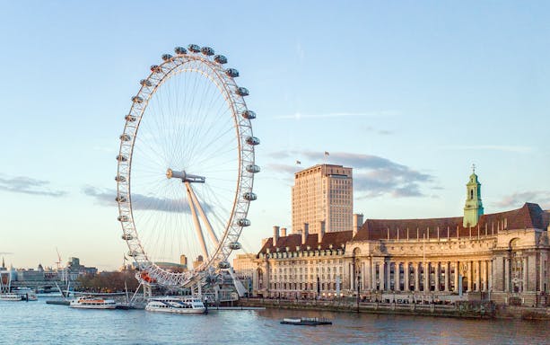 Tootbus passing the London Eye on a sunny day during the London Hop-On-Hop-Off Bus Tour.