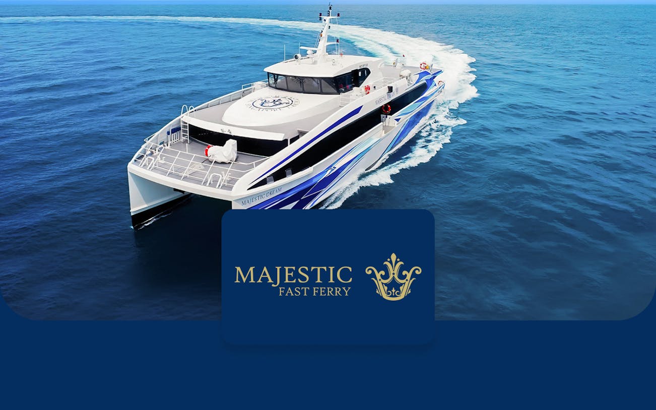 Fast ferry cruising on open sea, Majestic Fast Ferry logo displayed.