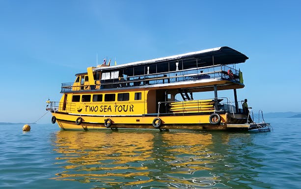 Yellow tour boat on Phang Nga Bay for sunset cruise with lunch and dinner.